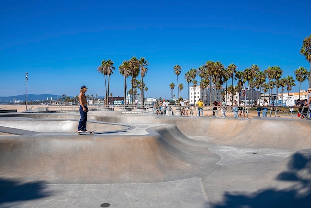 Hemdloser Mann, der im Sommer im Skatepark am Venice Beach Skateboard fährt