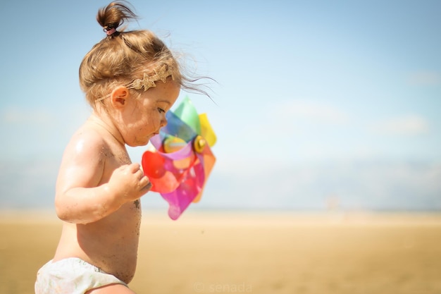 Hemdloses Mädchen mit Schraubengetriebe, das am Strand spazieren geht