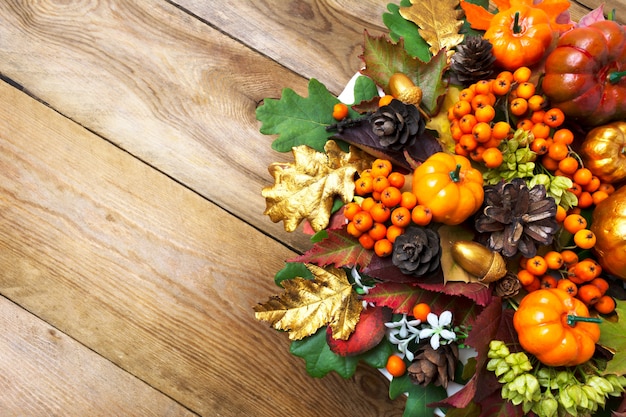 Herbst Arrangement mit Rahmen aus Kürbissen, Beeren und Zapfen