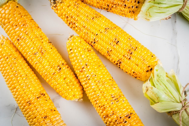 Herbst bbq, gegrillter Mais auf weißer Marmortabelle, Draufsichtkopienraum