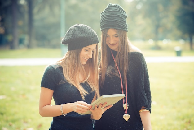 Herbst der jungen Paare der schönen Frauenmädchen unter Verwendung der Tablette