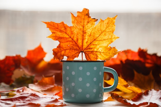 Herbst. Gefallene Blätter und eine rustikale Tasse warmen Tee