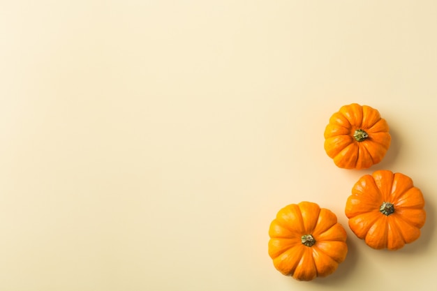 Herbst Herbst Erntedankfest Komposition mit dekorativen orangefarbenen Kürbissen. Flache Lage, Draufsicht, Kopienraum, Stillleben gelber Hintergrund für Grußkarten