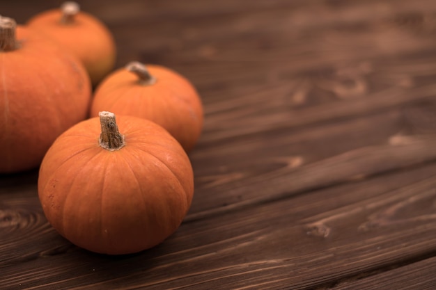 Herbst kleiner orange Kürbis auf einem Holztisch, die Ernte, das Symbol von Halloween.