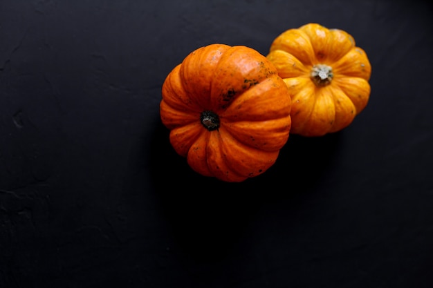 Herbst-Kürbis-Erntedank-Hintergrund - orange Kürbise über schwarzem Tisch