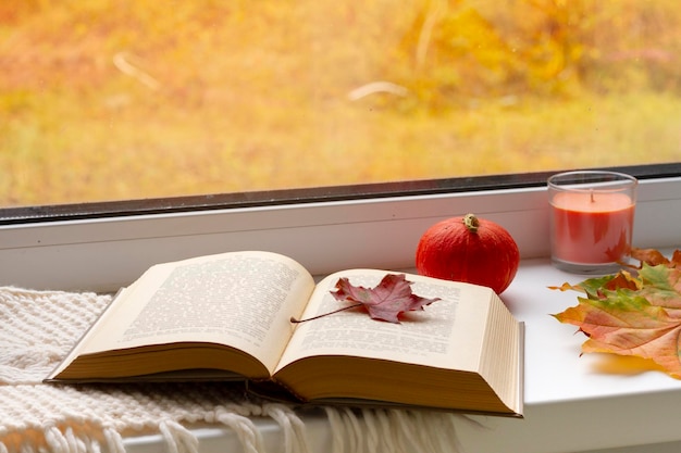 Herbst-Stillleben-Bücher lassen Tasse und Leuchter am Fenster