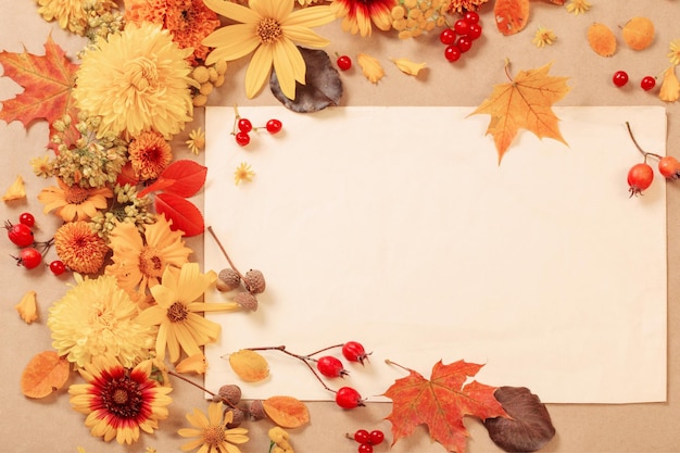 Herbstblumen und Blätter auf Papierhintergrund