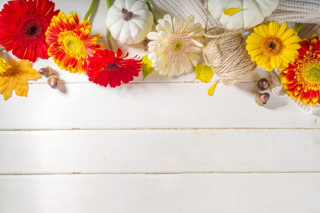 Herbstblumen und Dekorhintergrund mit Kürbissen