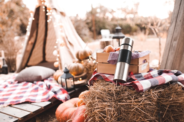 Herbstdekorationen. Heißer Tee in Thermoskanne mit ap