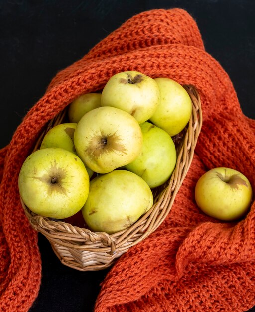 Herbsternte. Herbst-Konzept. Gelbe Äpfel in einem Korb. Dunkler Hintergrund. Selektiver Fokus. Ansicht von oben.