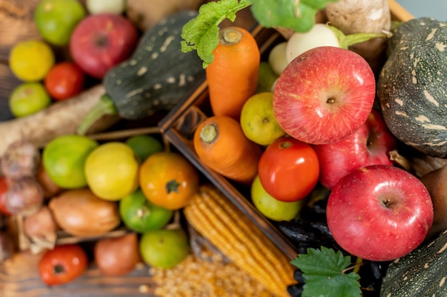 Herbsternte und Herbstsaison mit Bio-Obst und Gemüse auf Holzhintergrund