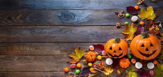 Foto herbstfeier halloween-hintergrund mit kürbissen und farbenfrohen herbstblättern auf einem holztisch