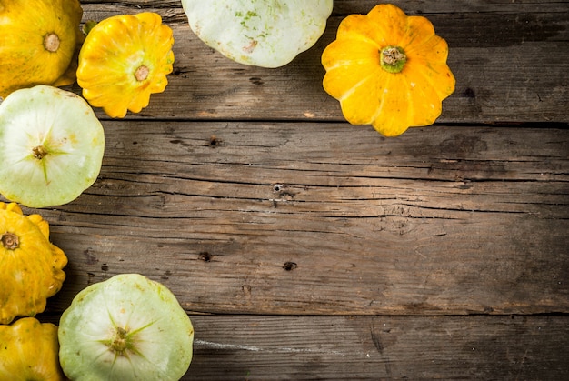 Herbstgemüse. Ernte. Frische rohe Biohofkürbis-Pastetchenwanne auf einem alten rustikalen Holztisch. Draufsichtkopienraum