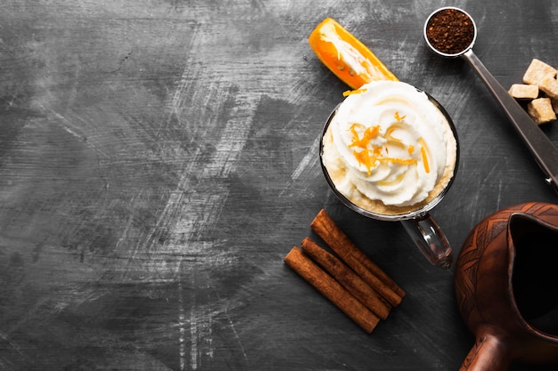 Herbstgetränk des Kaffees mit Orangensaft und Creme auf dunklem Hintergrund