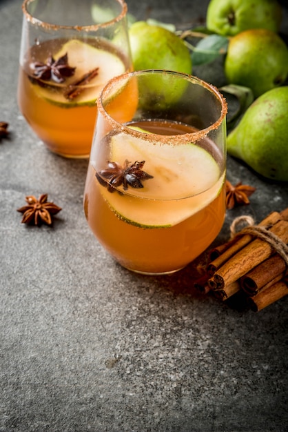 Herbstgetränke. Glühwein. Würziges Cocktail des traditionellen Herbstes mit Birnen-, Apfelwein- und Schokoladensirup, mit Zimt, Anis, braunem Zucker. Auf schwarzem Steintisch. copyspace