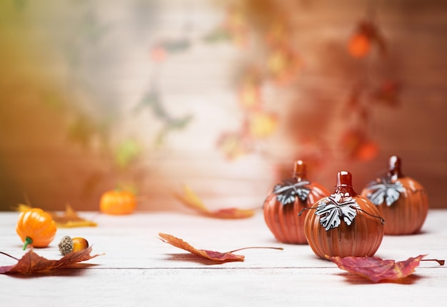 Herbsthintergrund aus gefallenen Blättern und Kürbissen auf Holztisch. Herbstlaub Hintergrund.