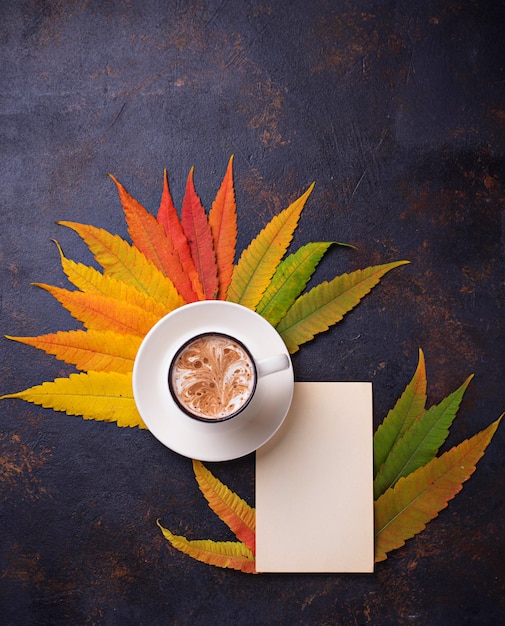 Herbsthintergrund mit Blättern und Tasse Kaffee.