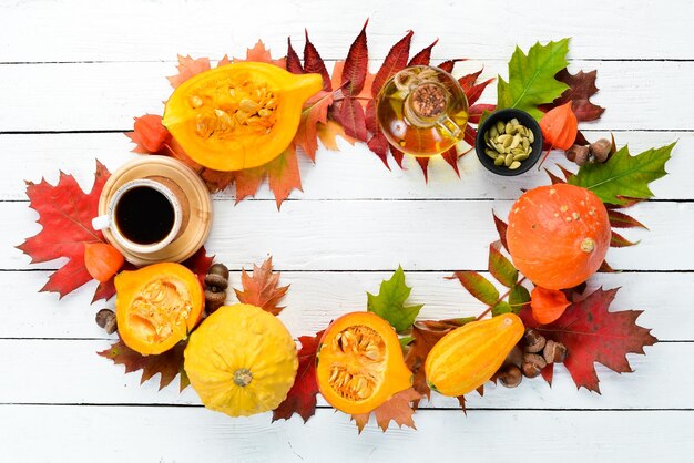 Foto herbsthintergrund mit kaffeekürbis-herbstblättern flach auf weißem holzhintergrund draufsicht freier platz für ihren text