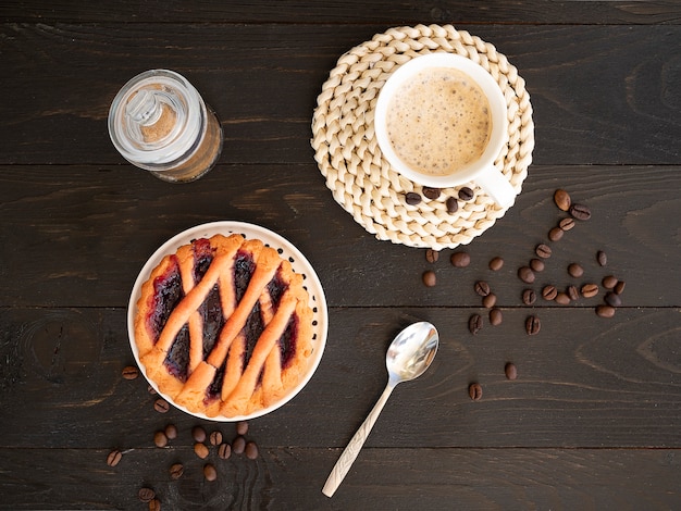 Herbstkaffee-Flachtisch mit serviertem Kuchen und heißem Latte-Becher-Kaffee-Frühstückskonzept