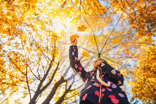 Herbstkind im Park mit gelben Blättern Selektiver Fokus Kind