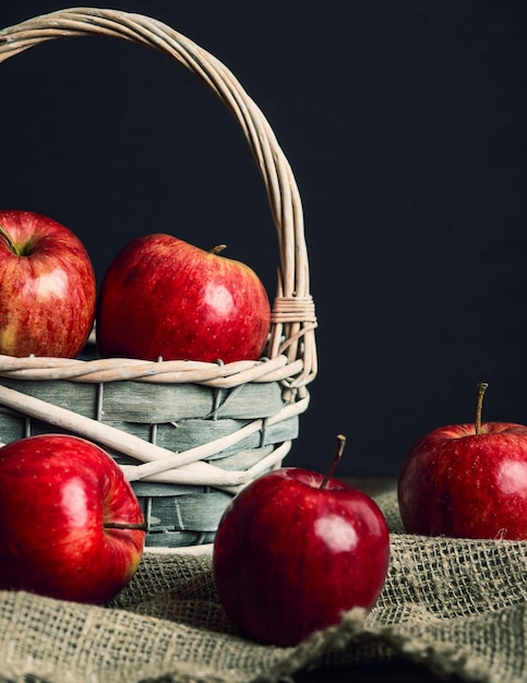 Herbstkomposition mit frischen roten Äpfeln in einem Holzkorb