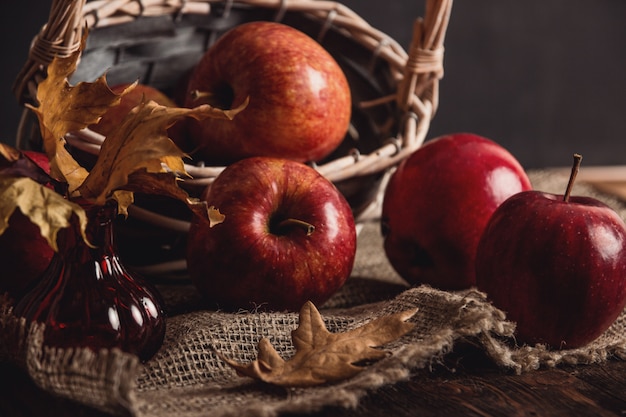 Herbstkomposition mit frischen roten Äpfeln in einem Holzkorb