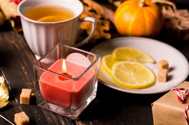 Herbstkomposition mit Kerzen, Kürbissen und Herbstlaub, Tasse Tee auf dunklem rustikalem Holztisch. Thanksgiving und Halloween-Feiertag. Konzept der Herbstsaison. Herbststillleben. flach legen, Platz kopieren