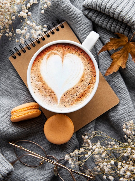 Herbstkomposition mit Tasse Kaffee und Herbstlaub