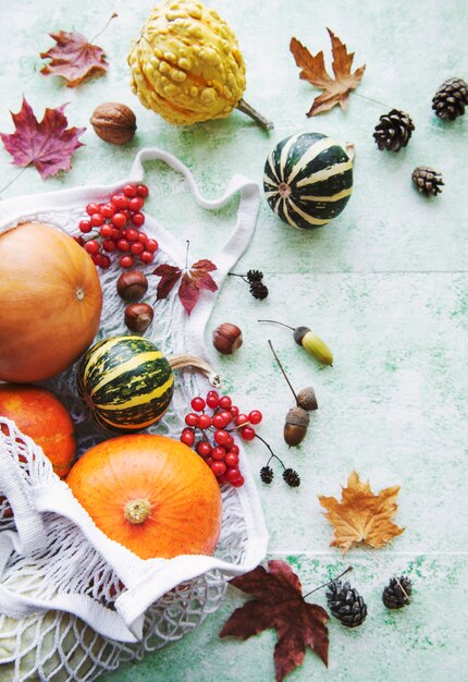 Foto herbstkomposition mit verschiedenen kürbissen in öko-string-tasche, thanksgiving-hintergrund.