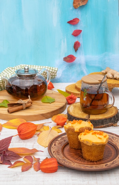 Herbstkomposition Tee und Kuchen auf einem Holztisch