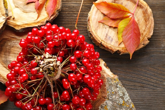 Herbstkompositionsbündel Viburnum und bunte Blätter auf Holztisch