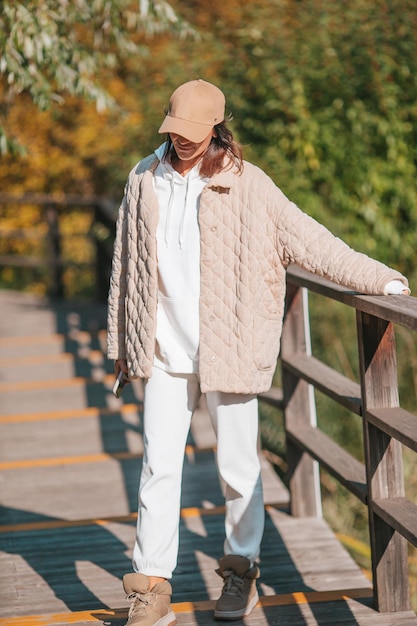 Herbstkonzept schöne Frau trinkt Kaffee im Herbstpark unter Herbstlaub