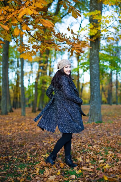 Herbstkonzeptporträt einer glücklichen jungen schönen Frau im Park oder Wald