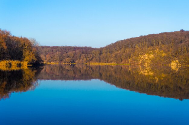 Herbstlandschaft Der See spiegelt den herbstlichen Wald wider