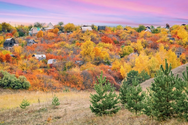 Herbstlandschaft mit bunten Herbstbäumen mit Holzhäusern