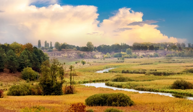 Herbstlandschaft mit einem Fluss in der Ebene