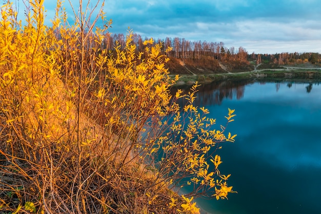 Herbstlandschaft mit schönen Wolken über dem See bei Sonnenuntergang. Gebiet Leningrad.