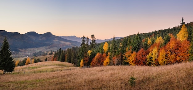 Herbstlandschaft von Waldhügeln und Bergen auf Sonnenuntergang