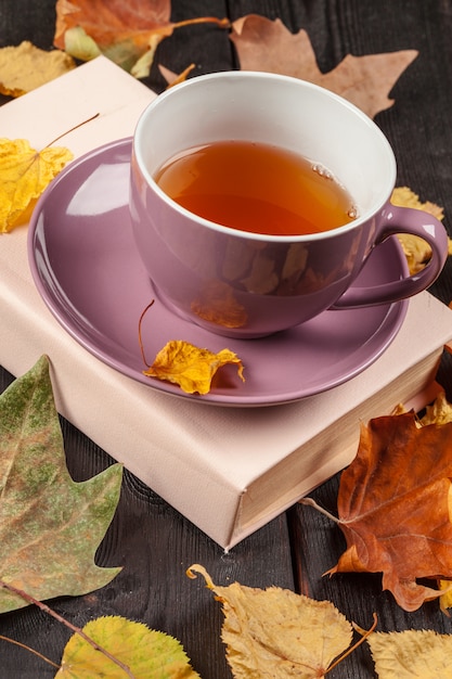 Herbstlaub, Buch und Tasse Tee