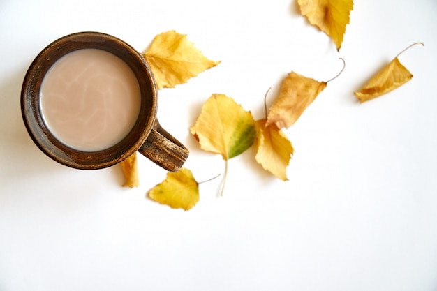 Herbstlaub mit Kaffee- oder Teeschale auf Weiß