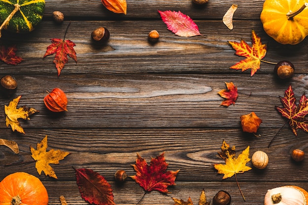 Herbstlaub mit Nüssen auf Holztisch