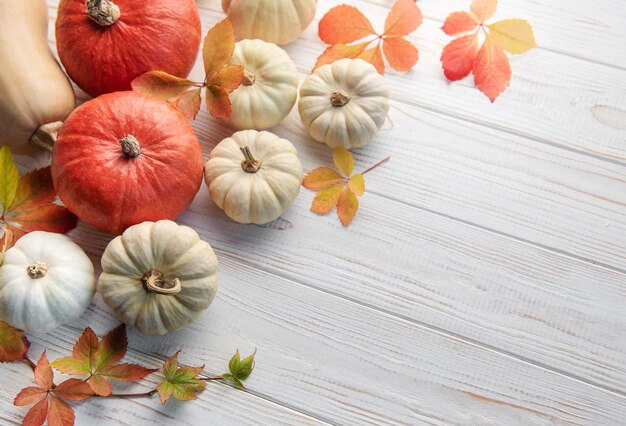 Herbstlaub und Kürbisse über altem Holzhintergrund