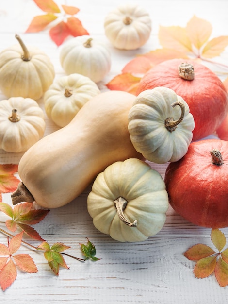 Herbstlaub und Kürbisse über altem Holzhintergrund