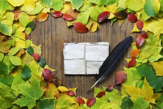 Herbstlaubhintergrund in Form des Herzens auf Holztisch