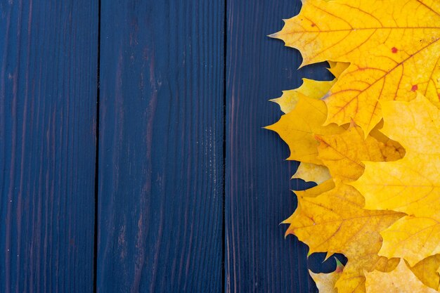 Herbstlaubrahmen auf hölzernem Hintergrund Draufsicht Fallgrenze gelb und orange Blätter Vintage Holztisch Kopieren Sie Platz für Text