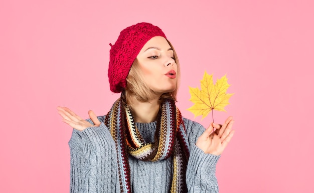 Herbstliche sinnliche Frau mit Ahornblatt Frau mit Herbstblatt gelbe Ahornblattfrau im roten Hut hält