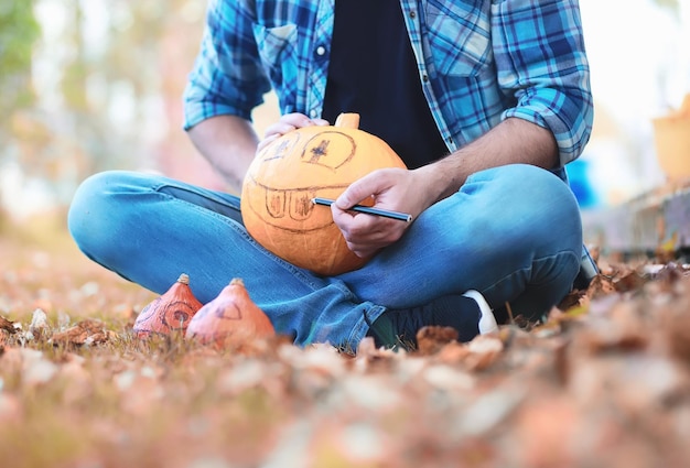 Herbstliche traditionen und vorbereitungen für den feiertag halloween ein haus in der natur eine lampe aus kürbissen schneidet am tisch aus