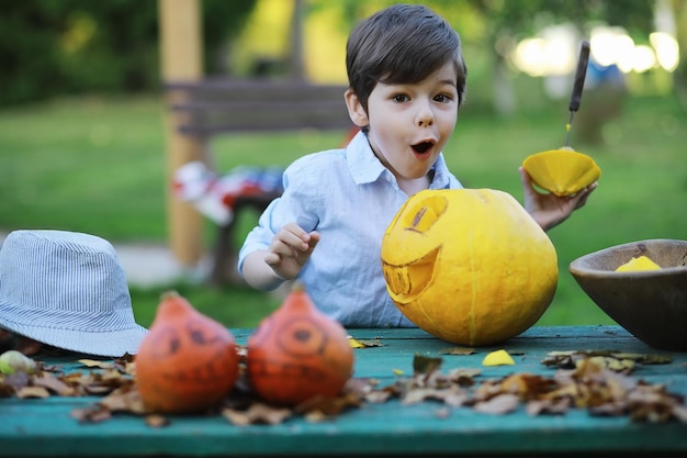 Herbstliche Traditionen und Vorbereitungen für den Feiertag Halloween Ein Haus in der Natur Eine Lampe aus Kürbissen schneidet am Tisch aus