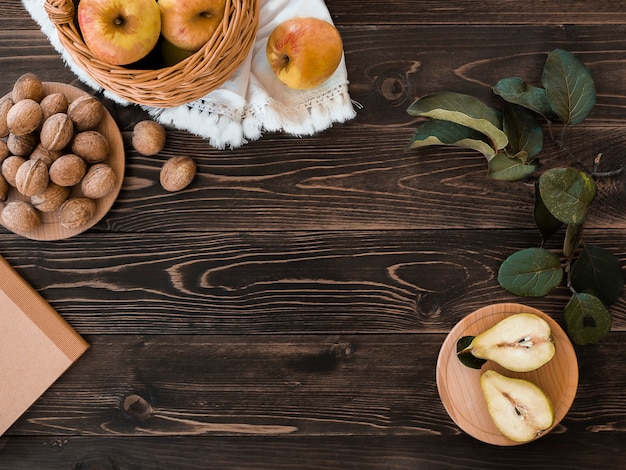 Herbstlicher flacher Schreibtisch mit servierten Früchten und Nüssen, Walnüssen, Äpfeln und Birnenscheiben kopieren Raumrahmen