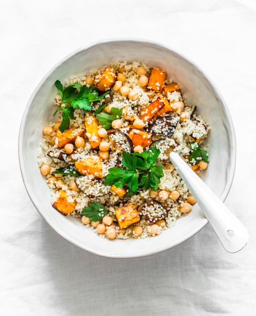 Herbstliches vegetarisches Mittagessen Couscous mit Kürbis und Auberginen auf hellem Hintergrund Draufsicht